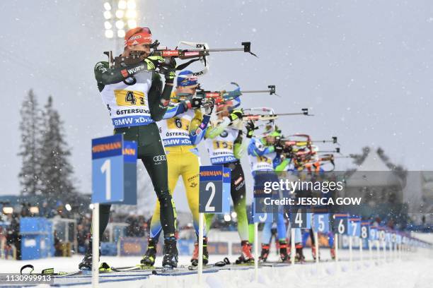 Arnd Peiffer of Germany and Martin Ponsiluoma of Sweden compete in the men's 4x7,5 km relay event at the IBU World Biathlon Championships in...