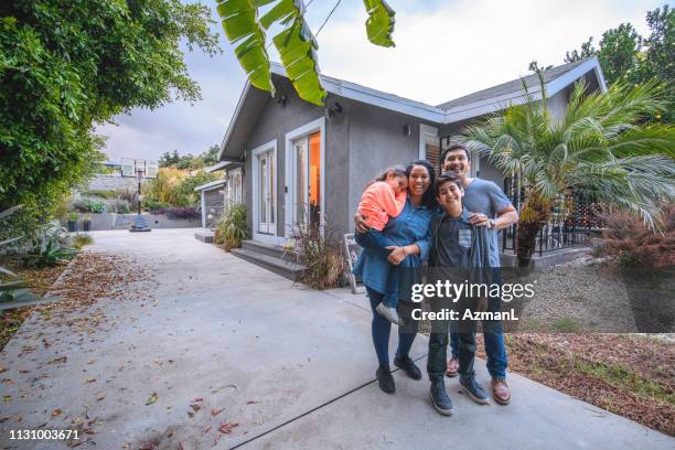 portrait of happy family against house - hispanic house stock pictures, royalty-free photos & images