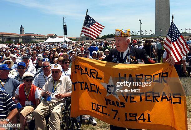 Edward Borucki of Massachusetts holds a banner as he walks through the crowd at the dedication of the World War II Memorial on Saturday, May 29 in...