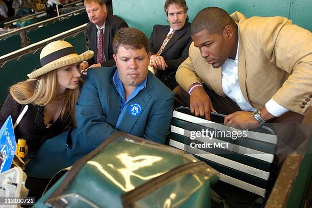 New York Giants' Michael Strahan, left, joins his wife Jean, right and friend, Mark Kent, as they watch the replay of the Smarty Jones loss in the...