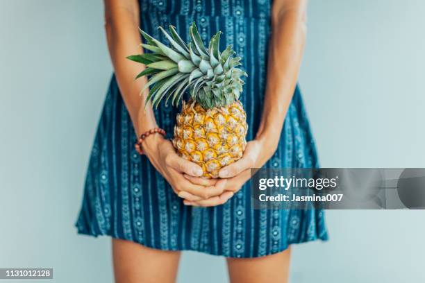 jonge vrouw holding ananas, close-up van fruit - pineapple stockfoto's en -beelden