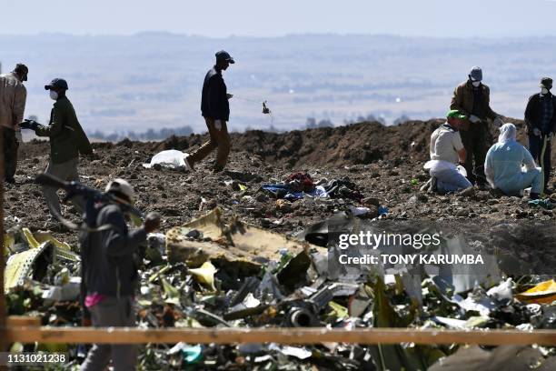 Oromo men hired to assist forensic investigators are at work at the crash site of an Ethiopian airways operated Boeing 737 MAX aircraft on March 16,...