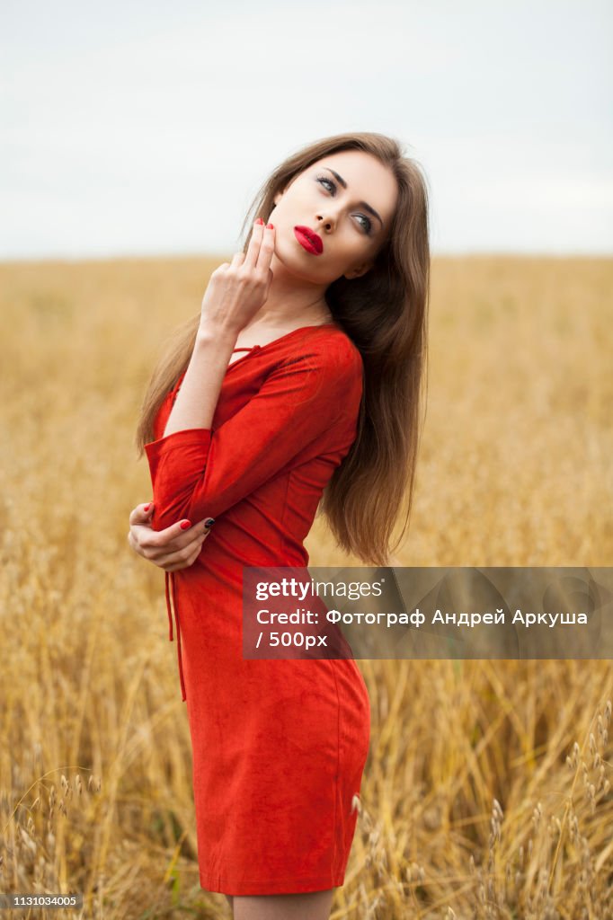Portrait Of A Young Brunette Woman In Red Dress