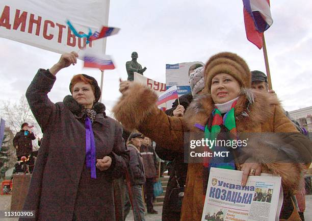 Protesters in Simferopol, Ukraine, carry Russian flags in front of a statue of Lenin in the central square. Residents in the Crimean south, just as...