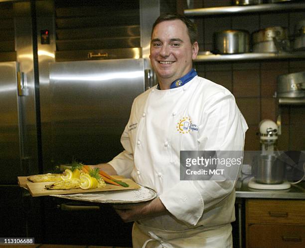 Finnish chef Mikko Kosonen holds a plate of broiled white trout with spring vegetables and duchess potatoes at the Finnish Embassy in Washington,...