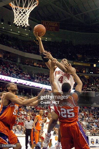 Maryland's Travis Garrison shoots over Clemson defenders Sharrod Ford , left and Cliff Hammonds in the first round of the ACC Tournament on Thursday,...