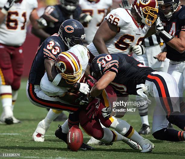 Landover, MD -- Washington Redskins running back Clinton Portis fumbles the ball as he is tackled by Chicago Bears Charles Tillman , left and Mike...