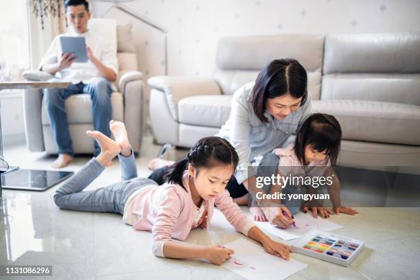 two girls drawing with parents at home - yongyuan hongkong stock pictures, royalty-free photos & images