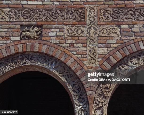 Decorative detail with cross and fantastic animals on the facade of the Pomposa Abbey, Codigoro , Emilia-Romagna, Italy, 9th century.