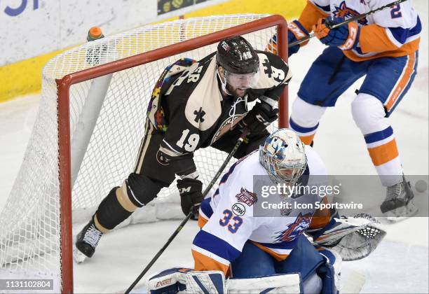 Hershey Bears right wing Riley Barber is hit into the net behind Bridgeport Sound Tigers goalie Christopher Gibson during the Bridgeport Sound Tigers...