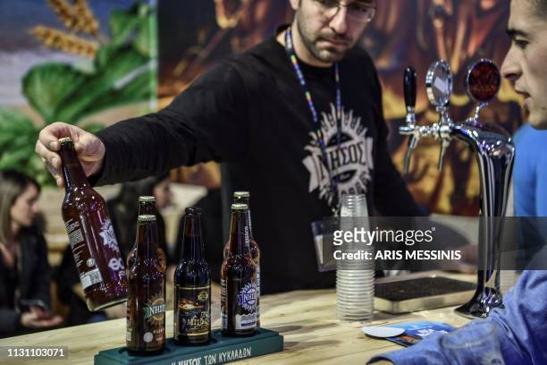 People visit Greek microbrewery kiosks during an exhibition near Athens on February 8, 2019. - The microbrewery sector has experienced an awakening...