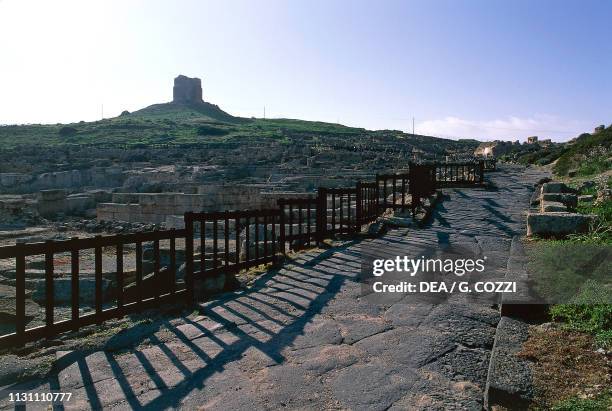 Ruins of the Phoenician-Punic and Roman city of Tharros, in the background the St John Tower, Sinis Peninsula, Sardinia, Italy.