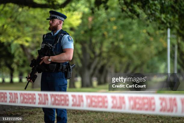 Police officer carrying an automatic rifle guards the area near Al Noor mosque on March 17, 2019 in Christchurch, New Zealand. 50 people are...