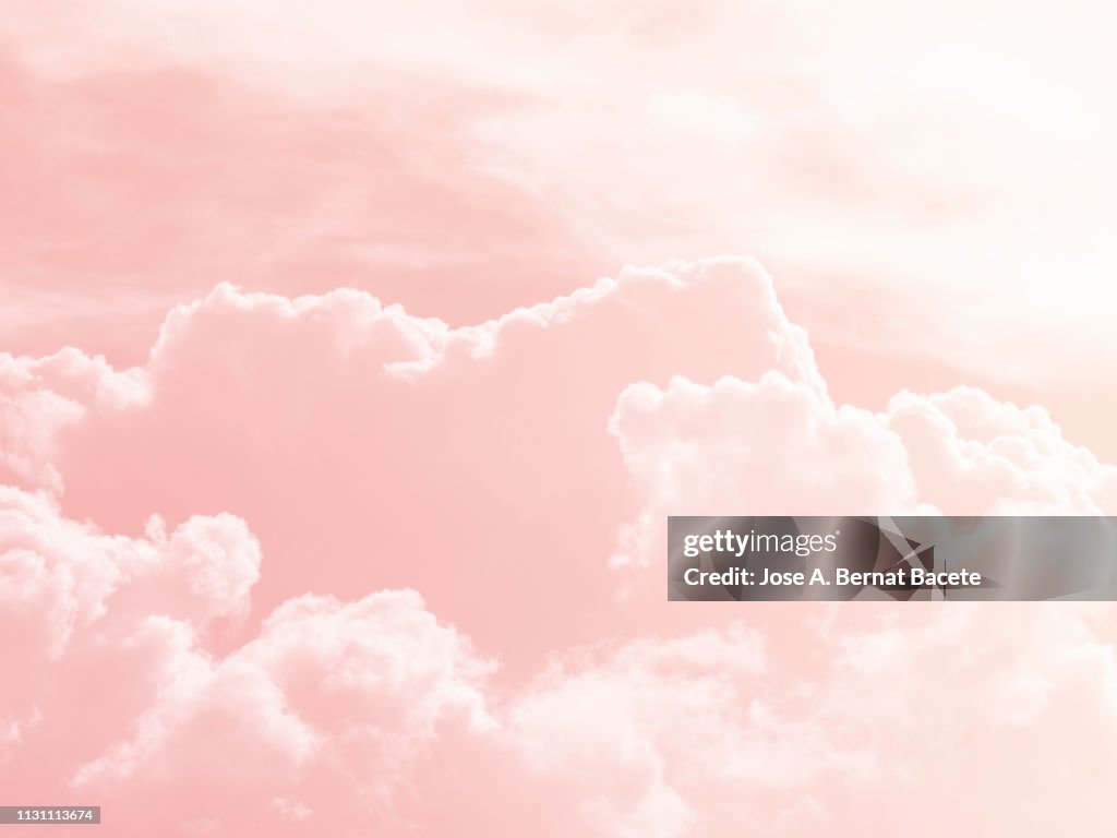 Background of a sky of pink soft color with white clouds.