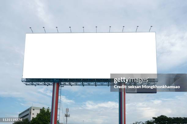 blank billboard at blue sky background - billboard fotografías e imágenes de stock