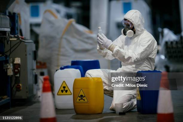 trabajador de fábrica trabajando con materiales peligrosos - hazmat fotografías e imágenes de stock