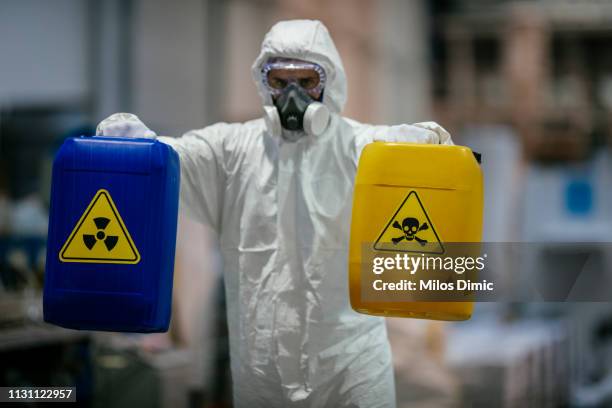 factory worker wearing gas mask and radioactive protection suit - sinal de radioatividade imagens e fotografias de stock