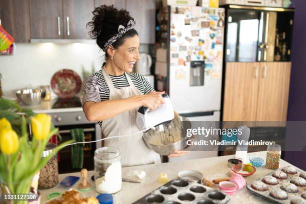 woman baking muffins - electric mixer stock pictures, royalty-free photos & images