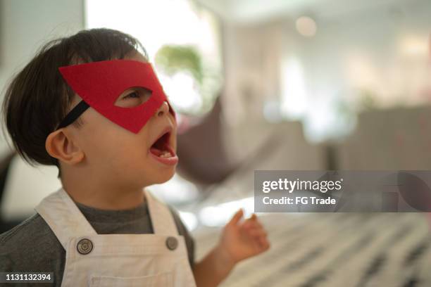 superhero down syndroom zoon spelen thuis - baby being held stockfoto's en -beelden