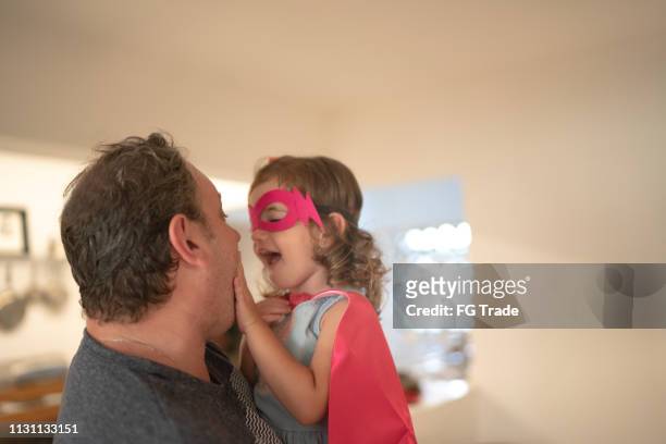vader en superheld dochter omarmen thuis - mask joke stockfoto's en -beelden