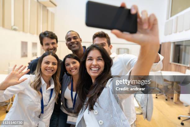 feliz grupo de compañeros de trabajo tomando un selfie en una oficina creativa - autofoto fotografías e imágenes de stock
