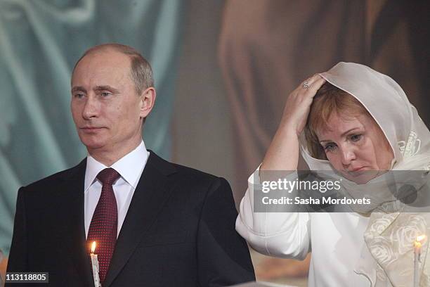Russia's Prime Minister Vladimir Putin and his wife Lyudmila pray during an Orthodox Easter service in the Christ the Saviour Cathedral on April 24,...