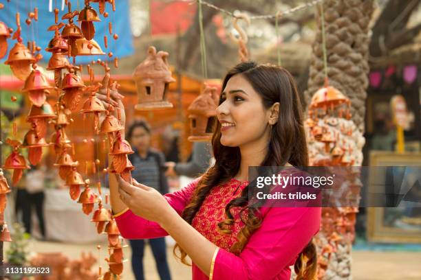 woman shopping for wall hanging at street market - wall hanging stock pictures, royalty-free photos & images