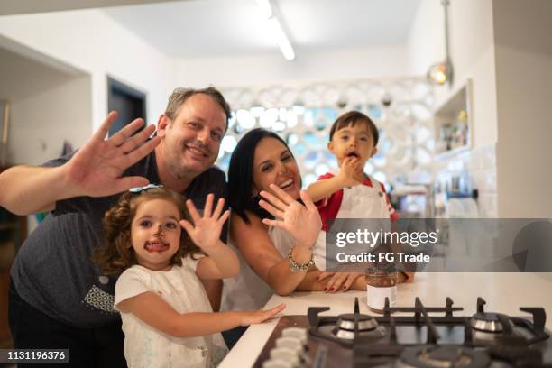 family with twin sibling (down syndrome boy and girl) portrait eating chocolate - family waving stock pictures, royalty-free photos & images