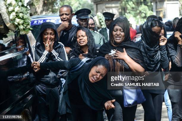 Mourners of victims of the crashed accident of Ethiopian Airlines react beside a funeral car during the mass funeral at Holy Trinity Cathedral in...