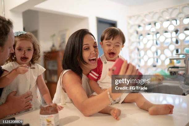 parents with down syndrome son and daughter taking a selfie after eating chocolate - sharing chocolate stock pictures, royalty-free photos & images