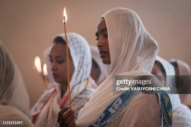 Devotees hold candles during a special service for the families of the victims of the crashed Ethiopia Airlines at Ethiopian Orthodox Church in...