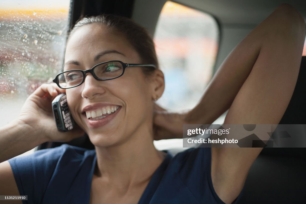 Woman sitting in passenger seat of car, using mobile phone