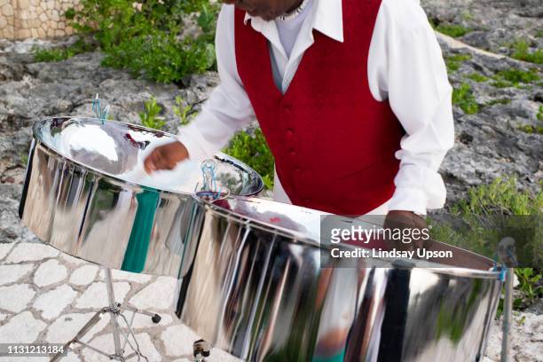 mature man playing steel drums, mid section - tamburo steel drum foto e immagini stock