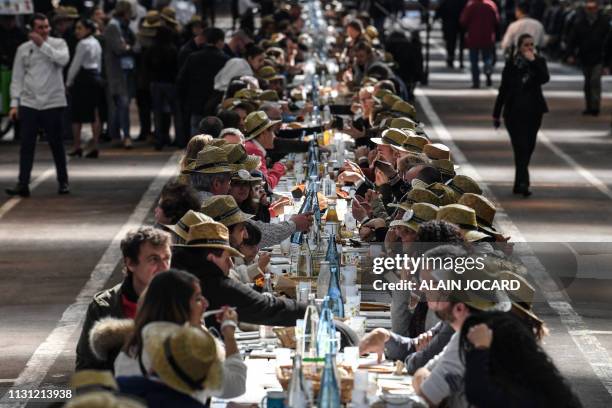 People take part in an attempt to break the Guinness World Records of the longest table to celebrate the international food market of Rungis' 50th...