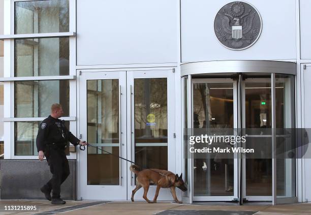 Police dog sniffs around the front entrance of the United States District Court Greenbelt Division on February 21, 2019 in Greenbelt, Maryland. A...
