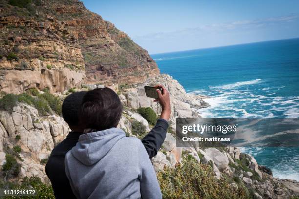 young african couple enjoying the view together - chapmans peak stock pictures, royalty-free photos & images