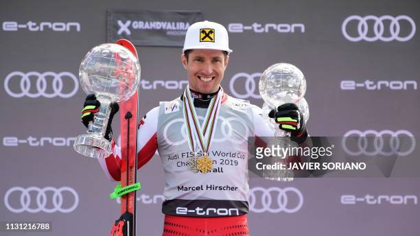Austria's Marcel Hirscher poses with his different crystal globe trophies during the podium ceremony after competing in the Men's FIS Alpine ski...