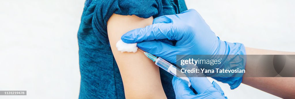 Vaccination of children. An injection. Selective focus.