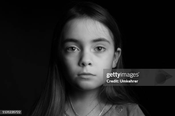 sad looking girl in front of black background - sad eyes stock pictures, royalty-free photos & images