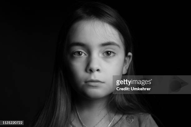 悲傷的女孩在黑色的背景面前 - sad child 個照片及圖片檔