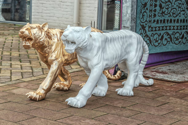 golden and white stone tigers on the street - zoo art stock pictures, royalty-free photos & images