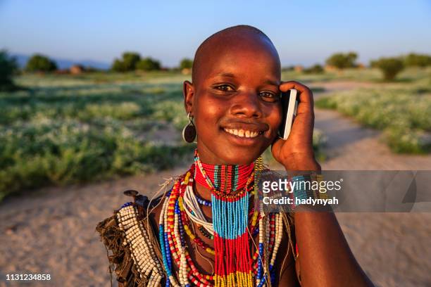 young woman from erbore tribe using smart phone, ethiopia, africa - omo valley stock pictures, royalty-free photos & images