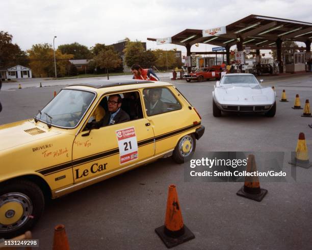 Yellow Renault 5 and a silver Chevrolet Corvette approach a parking lot checkpoint during a fuel efficiency driving event, 1975. Image courtesy US...