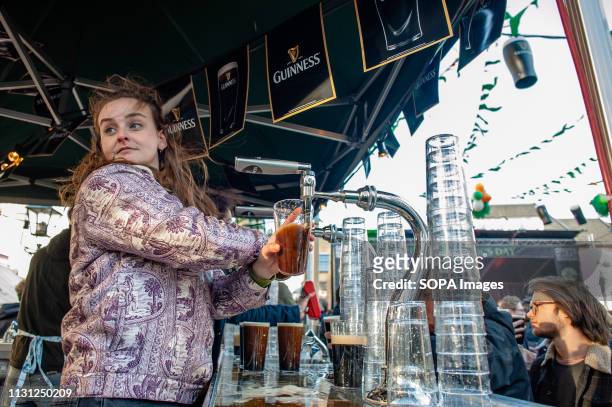 Bartender is seen serving pints of Guinness during the celebration. St. Patrick's day was celebrated for the ninth time in the Dutch city of The...