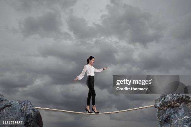 businesswoman walking on a rope - woman tightrope stock pictures, royalty-free photos & images