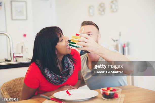 girlfriend takes a bite from slice of a cake - 1 year anniversary stock pictures, royalty-free photos & images