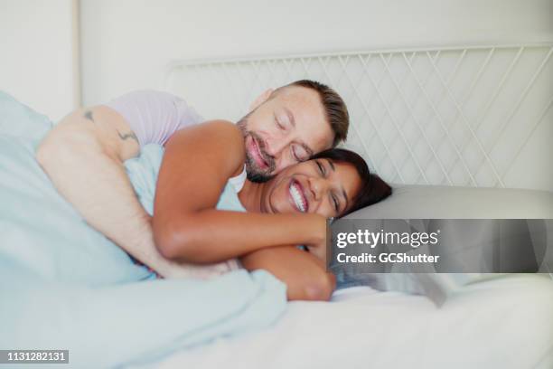 waking up to cuddles - romantic young couple sleeping in bed stock pictures, royalty-free photos & images