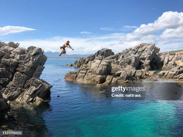 saltando de las rocas en el mar - salto desde acantilado fotografías e imágenes de stock