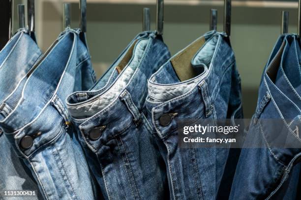 close up of jeans hanging on clothe sack in a row - vaquero fotografías e imágenes de stock