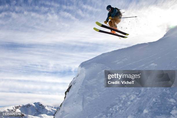 free-skier jumping off a big rock in a beautiful winter afternoon - skier jumping stock pictures, royalty-free photos & images